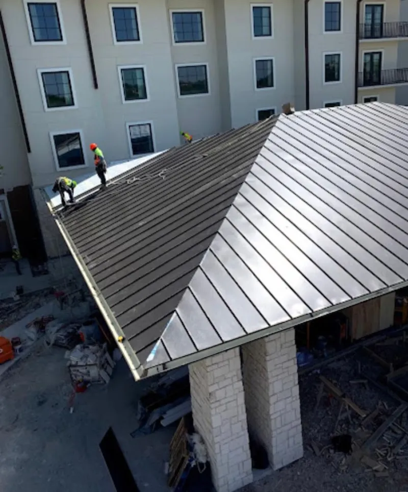 Crew installing standing seam metal roof panels on a commercial project in Lecanto